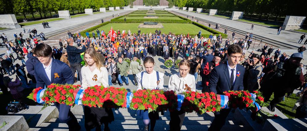 09.05.2023, Berlin: Ein Blumengesteck mit der russischen Flagge wird bei einer Gedenkveranstaltung die Treppen des Sowjetischen Ehrenmals im Treptower Park hinaufgetragen. Am 8. und 9. Mai jährt sich die Befreiung vom Nationalsozialismus zum 78. Mal. Foto: Christoph Soeder/dpa +++ dpa-Bildfunk +++
