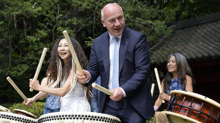 Kai Wegner, Regierender Bürgermeister von Berlin, versucht in der Residenz des deutschen Botschafters in Tokio die traditionelle japanische Trommel Taiko zu spielen.