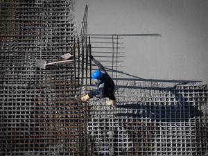 Berlin: Ein Arbeiter ist auf einer Baustelle am Alexanderplatz beschäftigt.