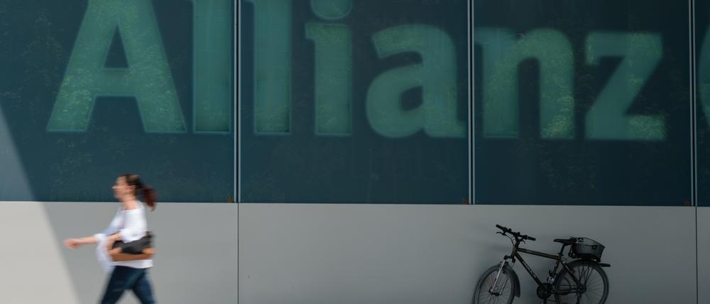Eine Frau geht am an dem Schriftzug «Allianz» an einem Gebäude des Versicherungskonzerns vorbei. 