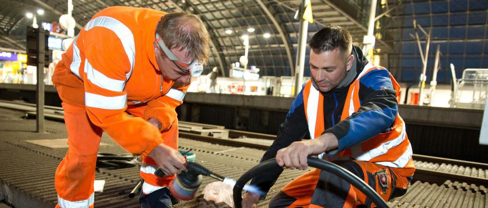 Arbeiter durchtrennen ein Kabel im Hauptbahnhof, um das neue Zugsicherungssystem einzubauen.