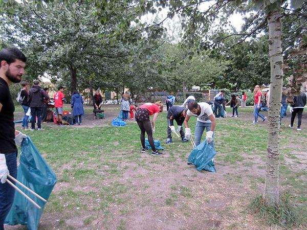 Flüchtlinge der Notunterkunft am Hauptbahnhof säubern gemeinsam mit Freiwilligen der Initiative "Serve the City" den Mauerpark.