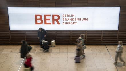 Reisende gehen durch das Terminal im Flughafen BER.