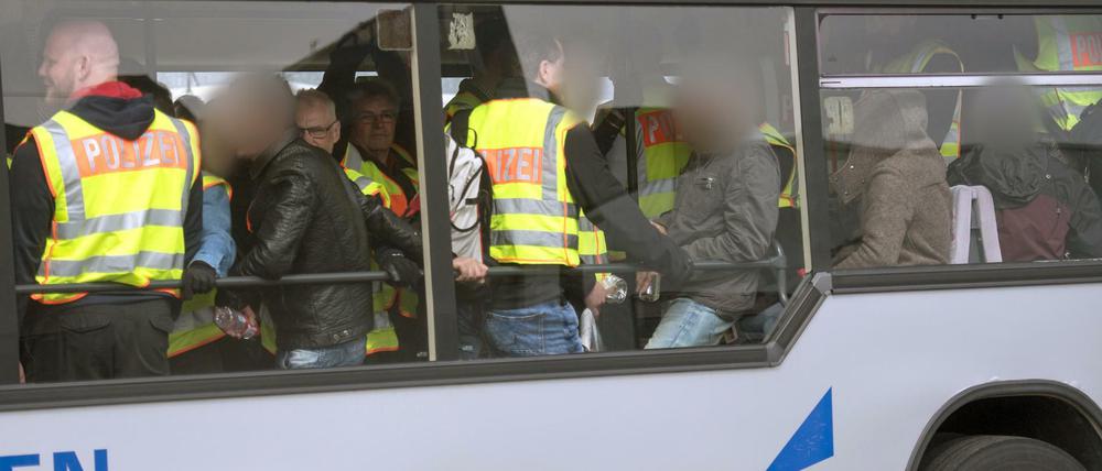 Vor der Abreise: Bundespolizisten in neongelben Westen begleiten abgelehnte Asylbwerber in einem Flughafen-Zubringer-Bus.
