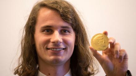 Peter Scholze, Mathematiker aus Berlin, zeigt auf dem Internationalen Mathematiker-Kongress 2018 seine Medaille. 