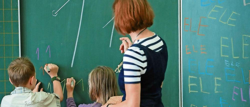 Schüler und Lehrerin an der Tafel in einer Grundschule in Berlin.