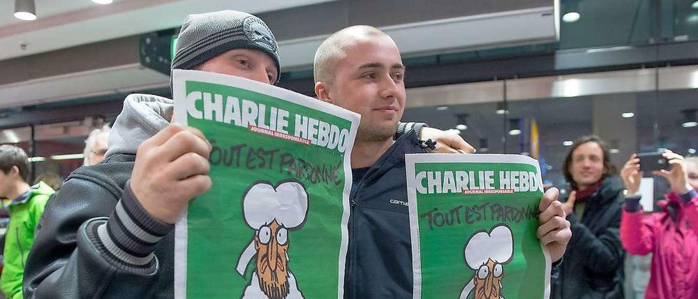 Kenny Rebenstock (links) und Nico Hirte haben am Samstagmorgen am Hauptbahnhof die einzigen beiden Ausgaben des französischen Satiremagazins Charlie Hebdo gekauft. Sie hatten seit Mitternacht vor der Buchhandlung gestanden.