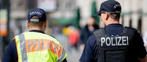 Zwei Polizeibeamte patrouillieren nebeneinander am Alexanderplatz.
