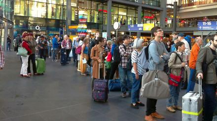 Die Wartenden in der Schlange am Infoschalter - um kurz vor acht Uhr am Hauptbahnhof Berlin.