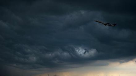 Ein Flugzeug vor dunklen Gewitter-Wolken (Archivbild).