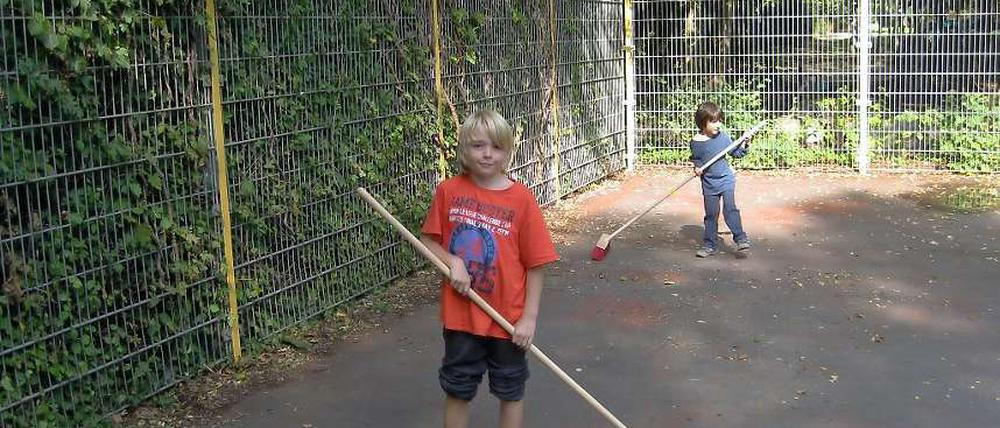 Der 10-jährige Germain macht mit seinen Freunden aus dem Jugendclub outreach den Fußballkäfig sauber.