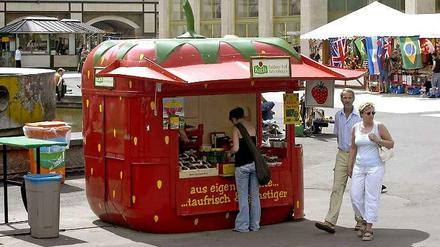 Die roten Erdbeer-Verkaufsstände gehören in Berlin wie hier am Alexanderplatz mit zum Straßenbild.
