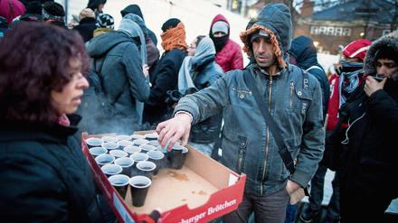 Helfer versorgen am in Berlin wartende Flüchtlinge vor dem Landesamt für Gesundheit und Soziales (LaGeSo) mit Heißgetränken.