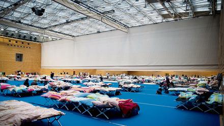 Voll, eng, provisorisch. Auch in einer Halle am Olympiapark sind Flüchtlinge untergebracht. Und so schnell wird sie wohl nicht geräumt werden.