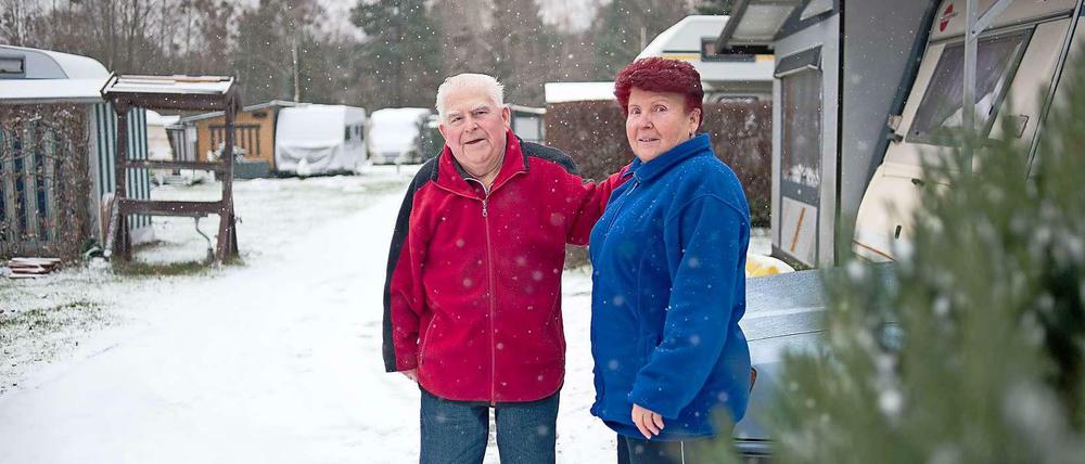 Das Rentner-Ehepaar Gericke steht im Schnee vor seinem Wohnwagen.