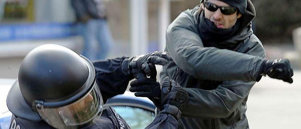 Ein gewalttätiger Demonstrant schlägt einen Polizisten nieder. Laut einer Potsdamer Studie wird die Gewaltbereitschaft gegen Polizeibeamte in Zukunft noch steigen - besonders von Seiten der rechtsextremen Szene. 