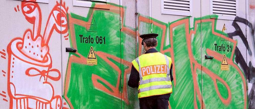 Den Schmierern auf der Spur. Ein Polizist untersucht ein Graffiti. 