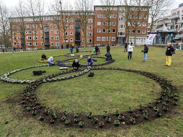 Hamburger Bürger pflanzen Blumen in Form der Olympischen Ringe