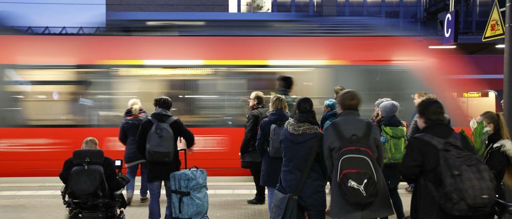 Menschen warten am Hauptbahnhof in Potsdam auf ihren Zug. 