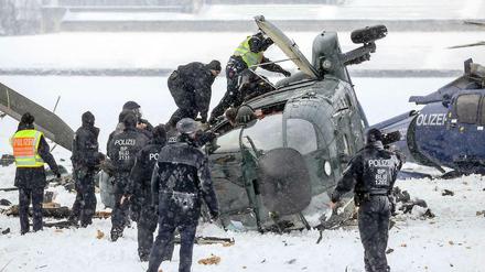 Crash im Schneetreiben. Retter bergen am 21. März 2013 die Passagiere und den getöteten Piloten aus dem Wrack. Der Hubschrauber der Bundespolizei war bei der Landung auf dem Maifeld am Olympiastadion abgestürzt.
