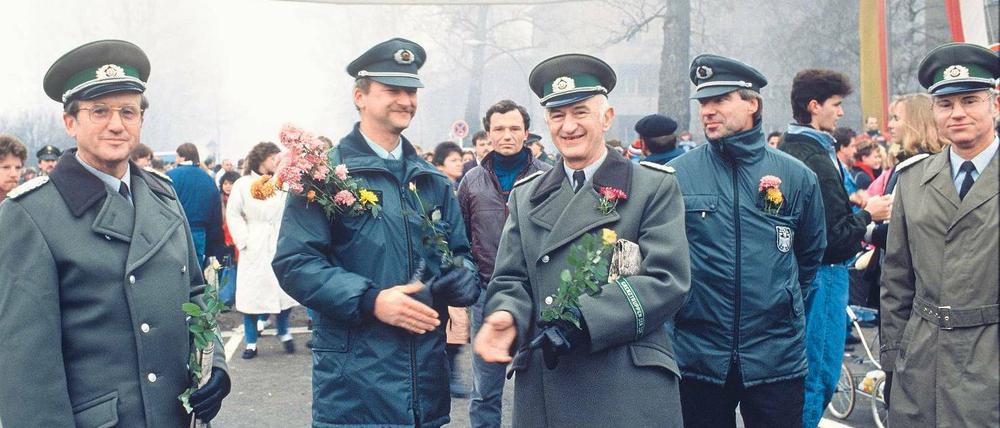 Sag es mit Blumen. Hallöchen am Ostpreußendamm: Ordnungshüter aus Lichterfelde und Teltow schütteln sich am 14. November 1989 die Hände. Foto: Zenit/laif