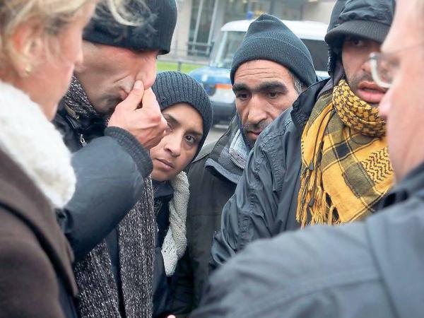 Ausharren in der Kälte. Die Flüchtlinge am Brandenburger Tor im Gespräch mit einem Vertreter der Polizei. 