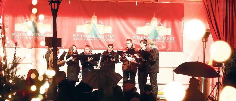 Schöne Stimmen. Auch auf Weihnachtsmärkten gibt es Konzerte. Vor dem Schloss Charlottenburg singt an jedem Abend ein Chor, hier der der Kantorei Mariendorf.