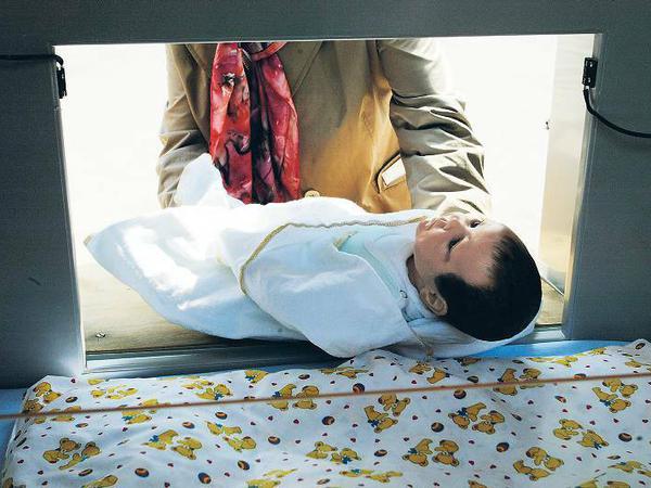 Rettung in höchster Not. Durch eine Klappe kann ein Baby in ein Wärmebettchen gelegt werden. Hier wird das am Neuköllner Krankenhaus mit einer Puppe demonstriert. 