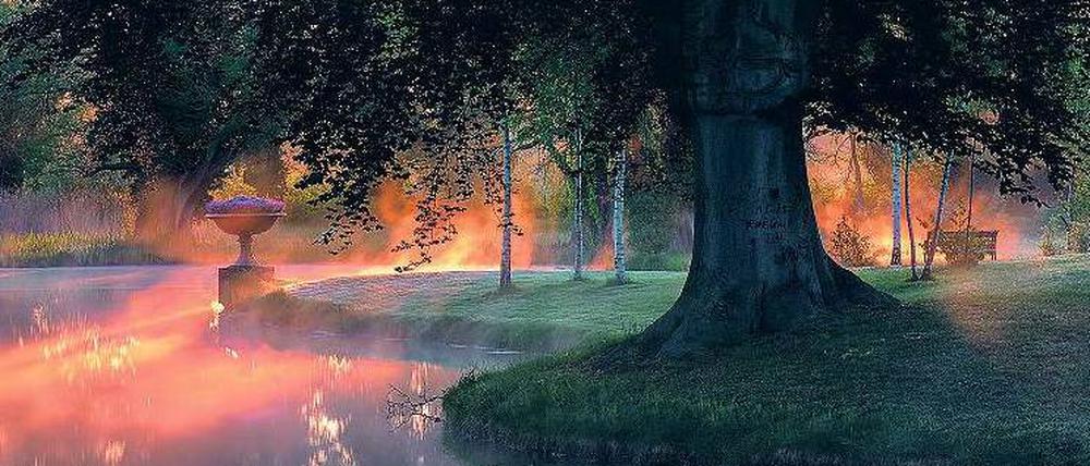 Morgennebel liegt über dem Teich zwischen Schloss Charlottenhof und den Römischen Bädern in Potsdam. 