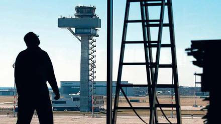 Schattenwirtschaft. Ein Arbeiter steht im März 2015 auf einer Baustelle im Terminalgebäude des neuen Hauptstadtflughafens, im Hintergrund ist der Tower zu sehen. 