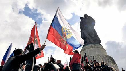 Fahne schwenken unterm Ehrenmal: Russische Biker und Russlandfans gedenken des Sieges der Roten Armee. 
