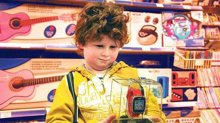 Ob das noch auf den Wunschzettel passt? Der siebenjährige Leopold schaut sich in der Mall of Berlin eine Smartwatch genauer an.