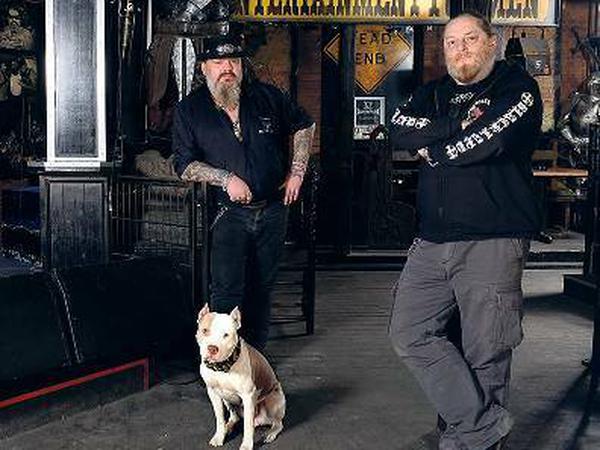Pille, 50, vom Rock-und-Metal-Pub Blackland in Prenzlauer Berg. Links steht Mitbetreiber Freddy mit Pitbull Athena.