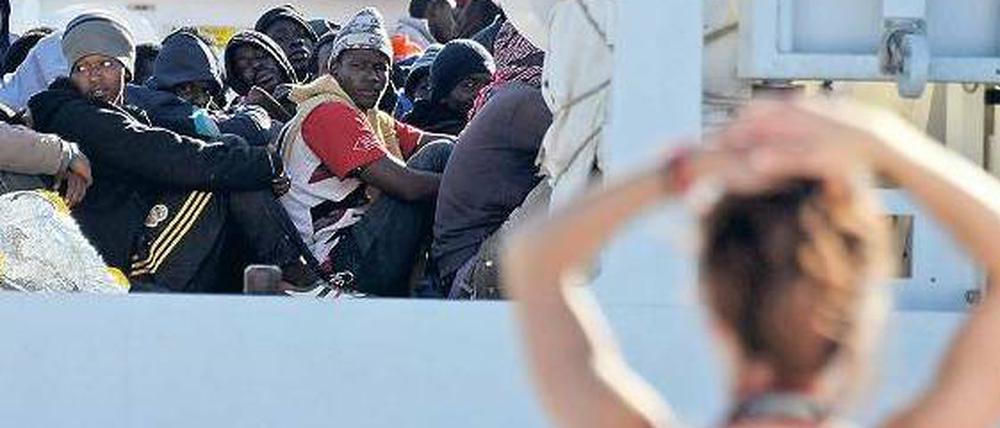 Zusehen bringt nichts. Überlebende aus Afrika erreichen Europa. Szene am Strand von Sizilien, April 2015.