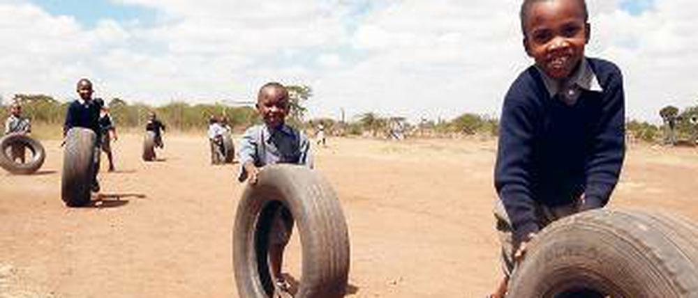  In der „Juja Farm“, der Einrichtung für ältere Waisenkinder von "Happy Life Children's Home" spielen Jungs mit Reifen. Alle schätzen es, in die Schule auf dem Areal außerhalb Nairobis gehen zu können. Einige Häuser auf dem Gelände sind noch im Bau befindlich, es mangelt noch an Geld.