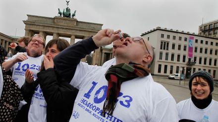 Runter damit! Anti-Homöopathie-Aktivisten ziehen sich vor dem Brandenburger Tor eine „Überdosis“ Globuli rein.