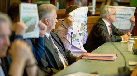Die Angeklagten im Jonny K.-Prozess verstecken sich hinter Zeitungen.