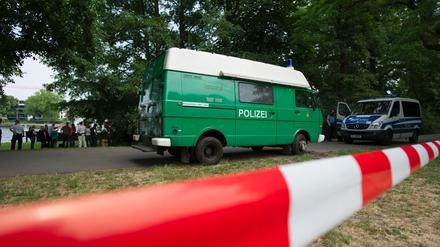 Polizeiwagen stehen am 13.06.2015 in Berlin im Treptower Park. Dort hatten Spaziergänger eine Leiche gefunden. Die Mordkommission ermittelt. 