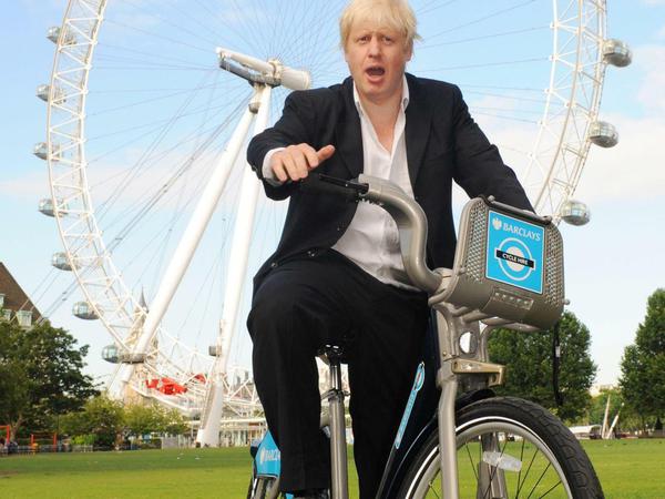 Der selbsternannte Radel-Bürgermeister von London, Boris Johnson, posiert vor der Kulisse des Riesenrades "London Eye" auf einem Fahrrad. Derzeit bekommen seine Pläne für neue Fahrrad-Autobahnen in London viel Aufmerksamkeit.