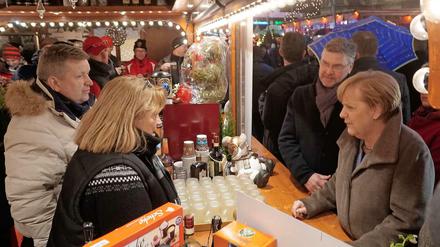 Bundeskanzlerin Angela Merkel und Michael Roden vom Schaustellerverband am Weihnachtsmarktstand der Familie Wollenschlaeger.