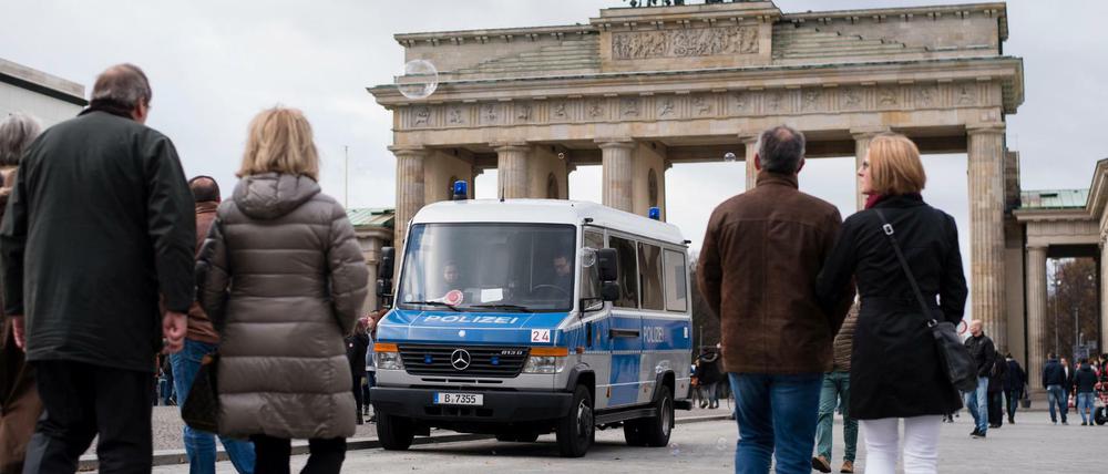 Ein Mannschaftswagen der Berliner Polizei steht vor dem Brandenburger Tor. 