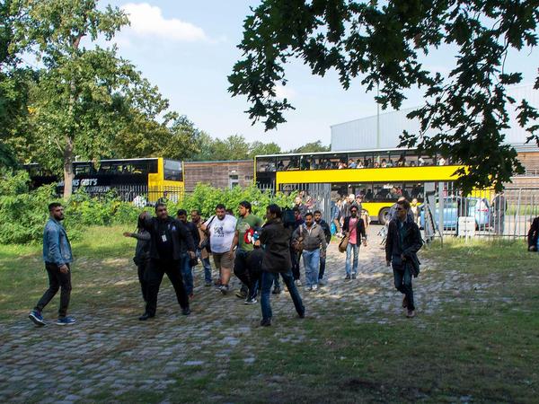 Erschöpft, aber auch froh: Flüchtlinge steigen am Olympiapark aus den BVG-Bussen.