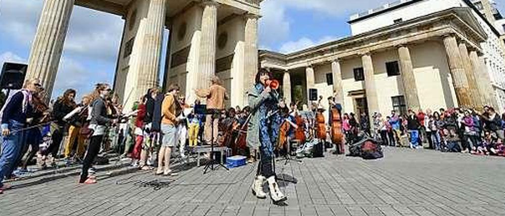 Hereinspaziert! Hier sagt die niederländische Sängerin Ellen ten Damme dem Publikum am Brandenburger Tor das Straßensymphonieorchester mit jungen Nachwuchskünstlern aus Amsterdam an - und singt dann gleich mal weiter.