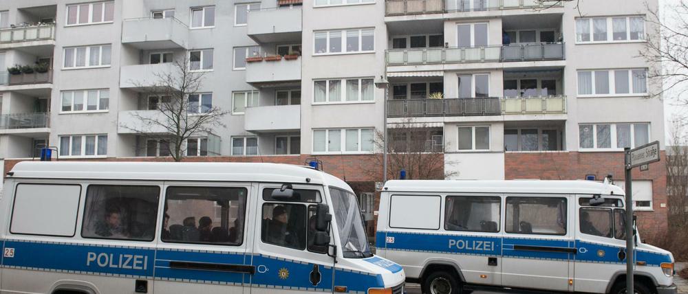 Polizeifahrzeuge stehen vor einem Gebäudekomplex in Alt-Hohenschönhausen. 