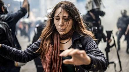 Eine Demonstrantin läuft in Istanbul in der Nähe des Taksim-Platzes mit geschlossenen Augen durch Schwaden von Tränengas.