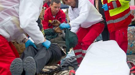Rettungskräfte heben einen der Flüchtlinge am Brandenburger Tor auf eine Bahre.