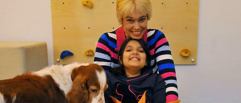 Ein fröhliches Trio. Physiotherapeutin Marion Jager und ihre Tochter Larissa zusammen mit Therapiehund Amy in Wilmersdorf.