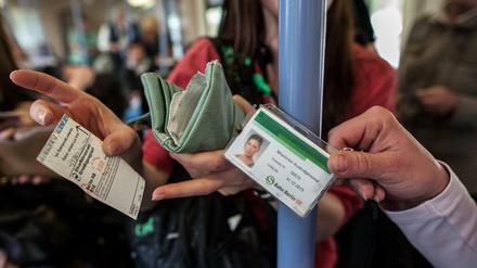 Eine Kontrolleurin lässt sich in der Berliner S-Bahn einen Fahrausweis zeigen. 