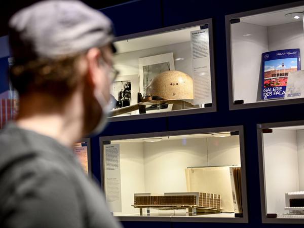 Ein Besucher der Ausstellung zum Palast der Republik hat den Helm des Architekten Heinz Graffunder im Blick.