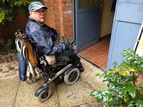 Fred Kutzner weist auf eine gefährliche Kante für Rollstuhlfahrer im Soldiner Kiez hin.
